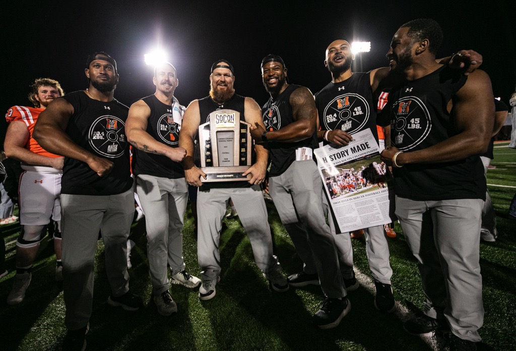 Mercer football players hold trophy