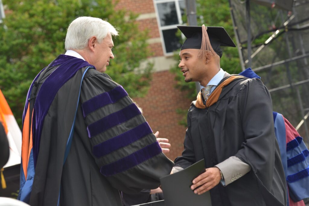 President Underwood shaking a recent graduate's hand