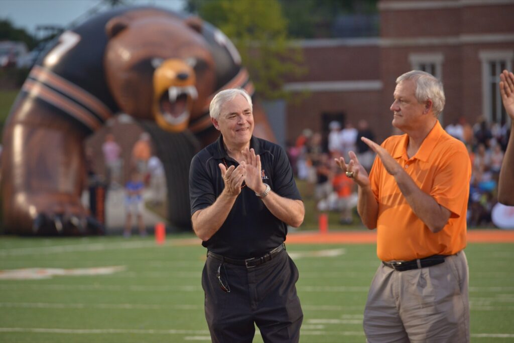 President Underwood standing with coach of Mercer's football team