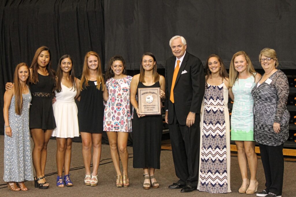 President Underwood standing with the women's golf team