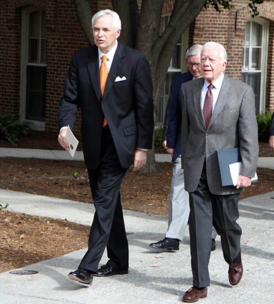 President Underwood walking with former president Jimmy Carter and Dr. Godsey